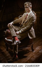 Men's Fashion. Portrait Of A Handsome Man In Elegant Classic Suit Sitting In An Armchair In A Luxury Apartment. Luxury Lifestyle. 