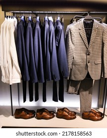 Mens Fashion Row Of Suits ,shirt In Different Colors 
On Hanger In A Retail Clothes Store With Shoes
