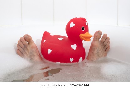 Men's Feet In A Bathtub, With Large Rubber Duck, Selective Focus