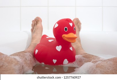 Men's Feet In A Bathtub, With Large Rubber Duck, Selective Focus