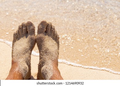 Mens Feet On The Beach Feet In The Sand On The Shore Clear Sea And Yellow Sand