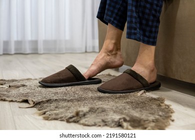 Men's feet put on house slippers. Warm feet - Shutterstock ID 2191580121