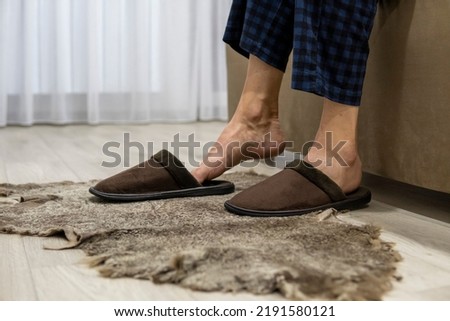 Men's feet put on house slippers. Warm feet