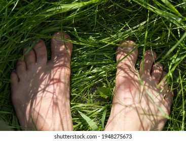 Mens Feet Standing On Green Grass, Selective Focus.