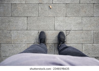 Men's feet wearing shoes stand on a paving stone road texture. Paving stones, paving background. Top view of men's feet. - Powered by Shutterstock