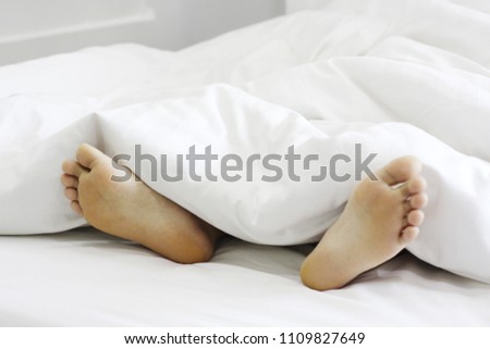 Men's feet in a white blanket. - Stock image Leg, Foot, Sleeping, Human Foot, Human Leg
