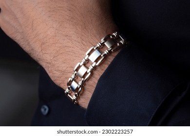 Men's gold bracelet on the arm of a young male model