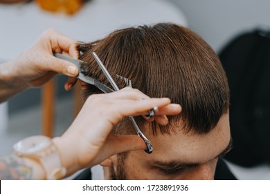 Men's Haircut At Home. The Hairdresser Cuts The Hair Of A Man