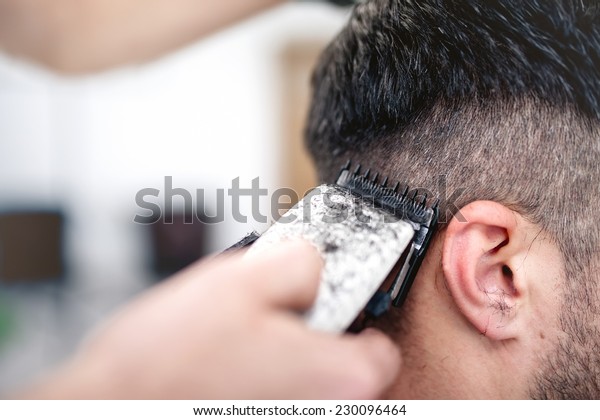 men\'s hairstyling and haircutting with hair\
clipper in a barber shop or hair\
salon