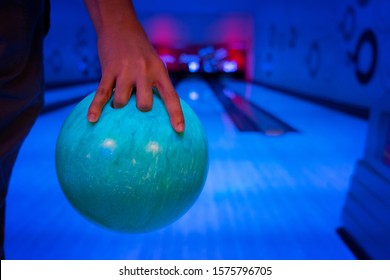 Men's Hand Holding A Blue Bowling Ball Ready To Throw