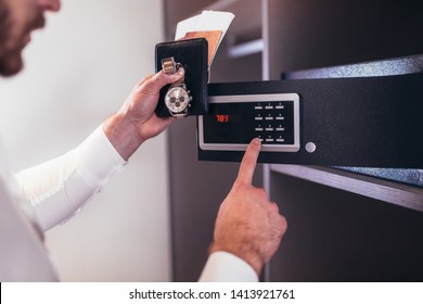 Men's Hand Opens A Safe Hidden In The Wardrobe. Small Home Or Hotel Safe 