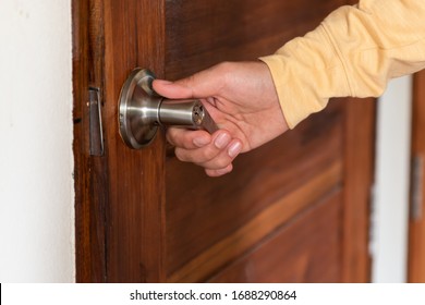 Men's Hand Opens Wooden Door Home. Close Up.