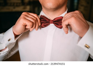 men's hands adjusting an accessory bow tie