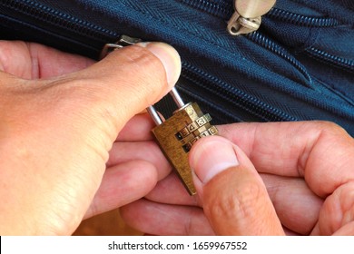 Men's Hands Close The Bag With A Combination Lock. A Small Padlock For A Case.