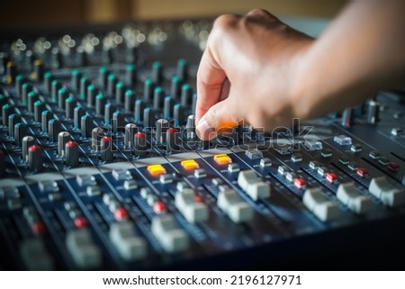 Men's hands are controlling the console of a large hi-fi system. Sound equipment. Control panel of a digital studio close-up mixer.