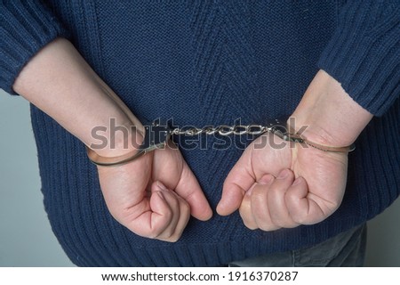 Men's hands in handcuffs chained from behind