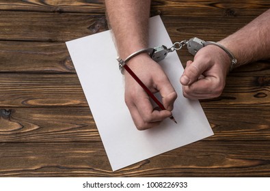 Men's Hands With Handcuffs Fill The Police Record, Confession. On Top See The Police Investigative Detective. Arrest, Bail, Criminal, Prison.