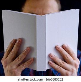 Men's hands hold a white book with clean pages