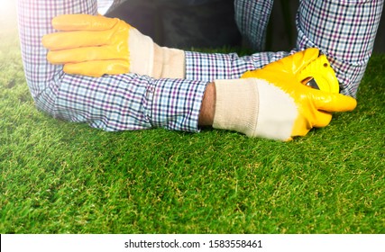 Men's Hands With Measure Tape On Artificial Grass.