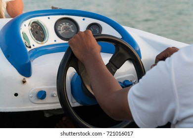 Men's hands on the steering wheel of a motor boat. - Shutterstock ID 721016017