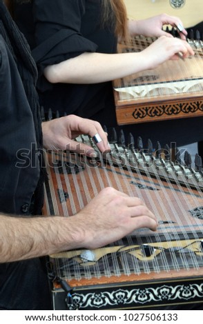 Men's hands playing on gusli