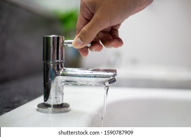 Men's hands turn off the tap to reduce global warming from turning on the waste water.