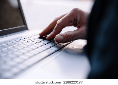 Men's hands typing on a laptop keyboard. Selective focus