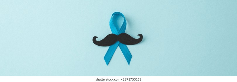 Men's Health Awareness Month. Top view of prostate cancer symbols - blue ribbon with mustache silhouette on a pastel blue backdrop, ideal for text or ads - Powered by Shutterstock