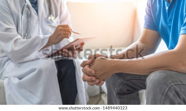 Men's health exam with doctor or psychiatrist working
with patient having consultation on diagnostic examination on male
disease or mental illness in medical clinic or hospital mental
health service 