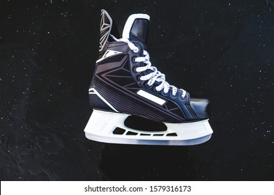 Men's ice hockey skates lying on the ice.