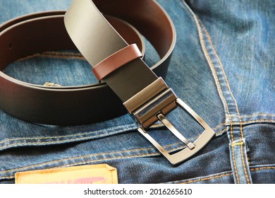 men's leather belt with metal buckle and blue jeans