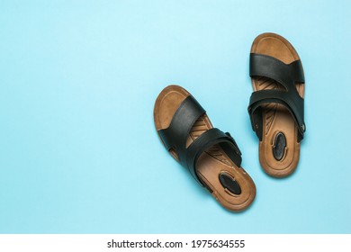 Men's leather sandals on a light blue background. Summer men's shoes. Flat lay.