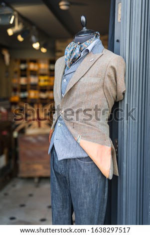 Men's Mannequin Dressed in a Casual and Elegant Style with Jacket, Scarf and Jeans in London Fashion Shop.