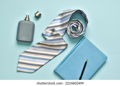 Men's necktie, cologne with diary on blue background. Copy space. Flat lay, top view. Fathers day, Boss day, mens day, valentine's day for holiday banner. Template for Greeting card. 