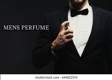 Men's Perfume. Man Using Cologne And Text On Dark Background