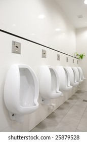 A Mens Public Bathroom With Urninals On The Wall