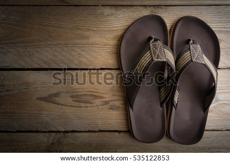 Men's sandals on wood floor.