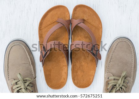 Men's sandals top view on rustic wood background.