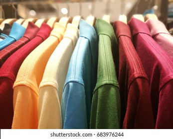 Mens Shirts In Different Colors On Hangers In A Retail Clothes Store