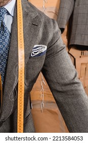 Men's Suit Maker Working On A Design, With Measuring Tape Hanging Around His Neck