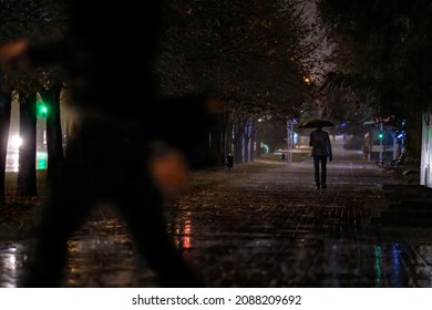 Men's Trench Coat An umbrella walking in the rain. night in the city. Photo of People Walking on Park - Powered by Shutterstock