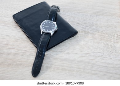Men's watch and wallet on the table. Home.