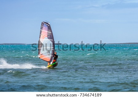 Men's windsurfer surfing in the lagoon