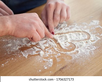 men's and women's hands draw a heart on a table covered with flour. baker's hand closeup.couple together Cooking pizza, bread during coronavirus - Powered by Shutterstock