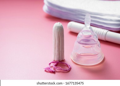 Menstrual Cup And Feminine Hygiene Tampon, Isolated On Pink Background. Feminine Hygiene Products With Copy Space.