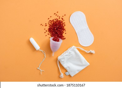 Menstrual Hygiene Products Including Menstrual Cup, Cotton Eco Bag, Sanitary Pad And Tampon On Orange Background