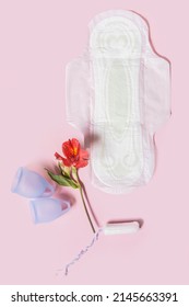 Menstrual Hygiene Products, Including A Cup, Pads And A Tampon On A Pink Background Top View.