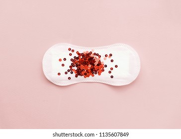 Menstrual pad with red glitter on pastel colored background. Minimalist still life photography concept