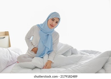 Menstrual Pain Or Stomachache Young Asian Woman Sitting On Bed. Beautiful Girl Hold Stomach And Feeling Painful With Unhappy Face. Healthy Concept