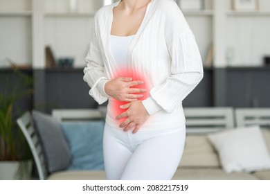 Menstrual pain, woman with stomachache suffering from pms at home, endometriosis, cystitis and other diseases of the urinary system, painful area highlighted in red